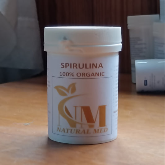Spirulina supplement container labeled '100% Organic' on a wooden surface.